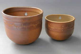 2 wodfired wall plant pots with design