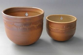 2 wodfired wall plant pots with design